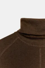 Jersey de punto confeccionado en lana, con cuello subido y manga larga. Presenta un diseño ajustado con detalle de costuras marcadas en el frente.