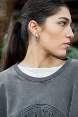 Aros de metal plateado con diseño de eslabones de cadena entrelazados.
