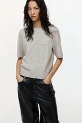 Remera corta en punto suave con cuello redondo acanalado, mangas cortas y bajo recto. Puños y bajo en punto acanalado.