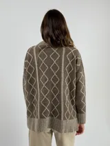 Sweater de lana color bordó con cuello alto y diseño de rombos y líneas verticales en rojo. Tiene puños y dobladillo acanalados.