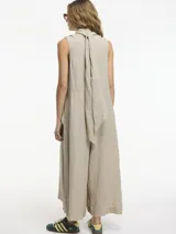 Mono negro de lino con escote en V, botones frontales, lazo ajustable en la cintura y bolsillos laterales ocultos.