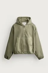 Cazadora relaxed fit de denim de algodón color verde militar, con efecto lavado, capucha, cierre frontal de cremallera con tirador circular, bolsillos frontales tipo canguro y acabados elásticos en puños y dobladillo.