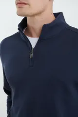Remera de manga larga con medio cierre frontal, confeccionada en tejido de punto acanalado con puños elásticos a tono.