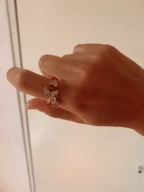 Anillo dorado ajustable con diseño abierto, decorado con tres dijes de mariposas pequeñas incrustadas con cristales brillantes.