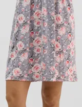Camisón corto de tejido soft, sin mangas, con escote redondo, aplique de botones y detalle plisado en el frente. Estampado floral en tonos rosados y grises.