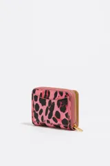Billetera pequeña con cierre de cremallera, exterior con estampado de leopardo en tonos rosa y negro brillante, y logo metálico de Bimba y Lola en color dorado.