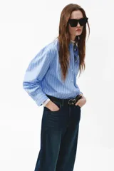 Jean de denim azul oscuro con diseño de piernas curvas y corte holgado de tiro medio.