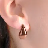 Aros tipo argolla pequeña con diseño de gota lisa y acabado brillante.