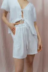 Short blanco de calce relajado con cintura elástica y lazo regulable. Presenta bolsillos amplios con ribete interior de color naranja neón.