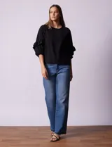 Blusa de gasa estampada con flores azules y violetas sobre fondo blanco, de manga 3/4 con volados.