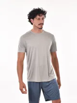 Remera deportiva de manga corta, color gris claro con sutil textura de rayas horizontales. Presenta cuello redondo y costuras reforzadas en los hombros.