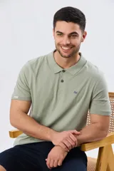Remera polo de manga corta en color azul melange, con cuello camisero, cierre frontal de dos botones y pequeño bordado en el pecho.