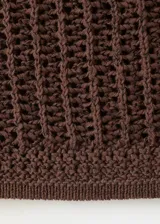 Cardigan de punto color marrón, con cuello redondo, manga corta y cierre frontal con botones.