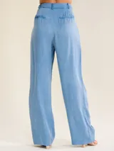 Pantalón de vestir tiro alto y pierna recta, confeccionado en suave tela chambray celeste, con diseño plisado en la cintura y bolsillos laterales.