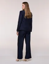 Blazer de sastre entallado color gris claro, con solapa de muesca clásica, cierre frontal de un solo botón y bolsillos frontales de vivo horizontales.