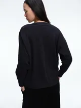 Cardigan de punto color marrón oscuro, con escote en V, manga larga y cierre frontal con botones metálicos dorados.