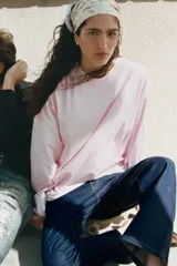 Camiseta oversize de manga larga color rosado, con cuello redondo y bajo recto.
