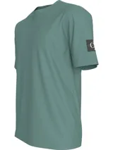 Remera verde de corte clásico y manga corta, con cuello redondo y logo de Calvin Klein en la manga.