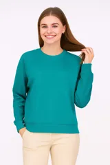 Buzo liso color verde esmeralda, de corte holgado y mangas largas.