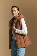 Chaleco acolchado de nylon color negro, con diseño capitoneado, capucha integrada y cierre frontal con tirador metálico.