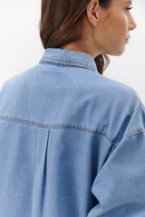 Camisa de jean celeste con botones metálicos envejecidos, manga larga y bolsillo en el pecho.