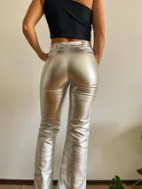 Pantalón plateado de corte recto con aberturas en el ruedo.