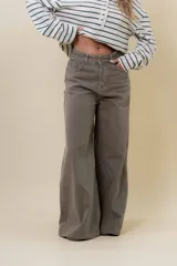 Pantalón de denim color marrón, de tiro medio-alto y calce wide leg con pierna amplia.