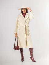 Tapado de paño sofisticado con solapas clásicas, cierre frontal de botones y bolsillos laterales. Presenta un diseño de corte recto y estructura elegante.