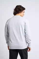 Buzo clásico de cuello redondo y manga larga, en color gris melange. Presenta un ajuste regular y un logo bordado con detalle en goma en el pecho.