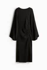 Vestido midi negro con textura, escote bote, mangas largas tipo trompeta y diseño ajustado con frunces laterales que generan un efecto drapeado.