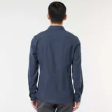 Camisa de manga larga con corte slim, confeccionada en tejido dobby con un sutil patrón geométrico repetitivo en color azul oscuro.