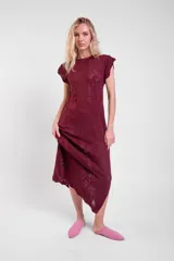 Vestido largo de crochet color crudo, con mangas cortas con volados y aberturas laterales, confeccionado en tejido calado de algodón con diseño ornamentado.