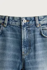 Jeans flare fit de denim de algodón en color celeste con lavado efecto desgastado. Presentan diseño de cinco bolsillos, tiro medio, cierre frontal con cremallera y botón, y bajo con acabado irregular.