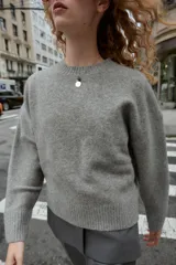 Jersey de punto color vino tinto, de cuello redondo y manga larga, con acabado acanalado (rib) en puños, cuello y bajo.