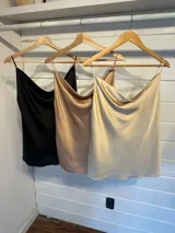 Musculosa de satén con escote drapeado tipo buche y breteles finos ajustables.