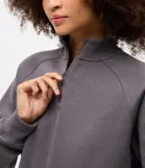 Buzo de algodón con felpa, de corte estructurado y diseño cropped. Presenta cuello alto con medio cierre frontal, mangas largas con puños elásticos y ruedo con elástico ancho.
