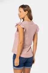 Remera lisa de color rosado con cuello redondo y mangas cortas con detalles de volados en broderie.