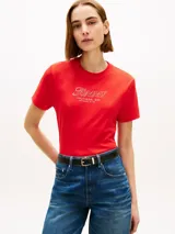 Remera Tommy Hilfiger de manga corta y cuello redondo, color rojo. Presenta un diseño gráfico bordado en el pecho con el nombre de la marca y texto descriptivo, además de la clásica bandera bordada en la manga.