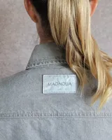 Sobrecamisa de denim azul con cuello camisero, cierre frontal con botones, mangas largas con puños abotonados y dos bolsillos con solapa en el pecho.