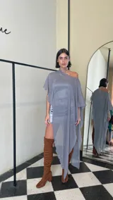 Vestido corto de dos piezas compuesto por una base strapless con frunces y acabado satinado, acompañada de una capa transparente desmontable de corte asimétrico.