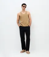Pantalón de corte recto con textura de líneas verticales, confeccionado en algodón. Presenta cintura estructurada con presillas, cierre tradicional con botón y bolsillos funcionales.