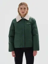 Campera verde con cuello de piel sintética blanca, cierre de botones a presión, bolsillos frontales y elástico en el dobladillo inferior. El forro interior es de algodón estampado.