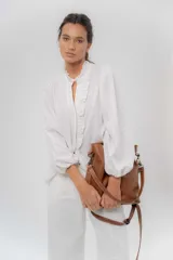 Camisa de manga larga color beige con diseño a rayas sutiles, cuello mao con volados y abertura frontal con detalles de volados a un lado.
