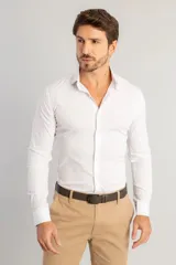 Camisa de vestir blanca de manga larga, con cuello clásico y cierre frontal de botones. Confeccionada en tejido de tricolina con elastano para mayor comodidad y ajuste.