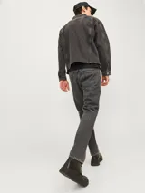 Jean de corte relaxed fit, color gris lavado, con diseño clásico de cinco bolsillos y cierre frontal con botones.