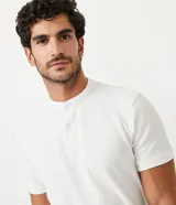 Polo de hombre de manga corta, color beige claro, con cuello mao y tapeta de dos botones.