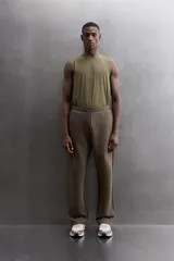 Pantalón jogger relaxed fit Zara Athleticz de tejido técnico compacto elástico con mezcla de algodón. Presenta cintura elástica ajustable con cordón, bolsillos laterales en la cadera, bolsillo trasero con cierre de cremallera, bajo ajustable con elástico y detalle de logo estampado en la pernera.