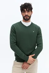 Sweater de punto color gris melange, con escote en V, manga larga y logo bordado en el pecho. Presenta puños y ruedo acanalados.