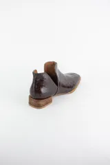 Botin de cuero con acabado grabado efecto avestruz, diseño con aberturas laterales y taco bajo cuadrado.