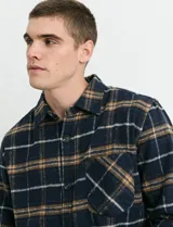 Sobrecamisa de manga larga con diseño a cuadros, cuello camisero y bolsillo frontal. Confeccionada en tejido de poliéster y algodón, sin forro.